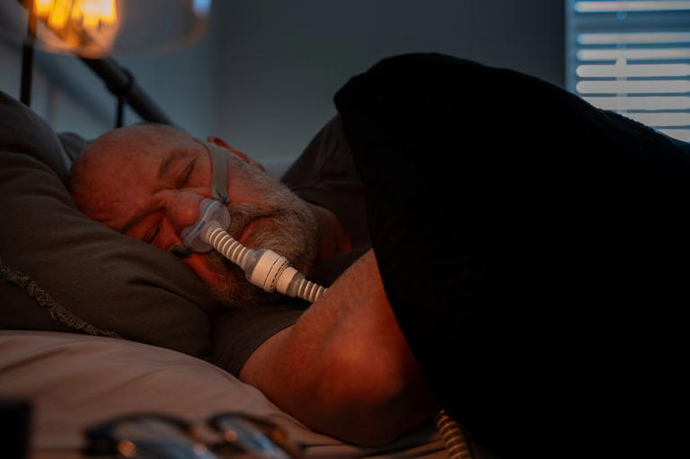 A Mature Adult Man Wearing a CPAP (Continuous positive airway pressure) Machine after being diagnosed with Sleep Apnea