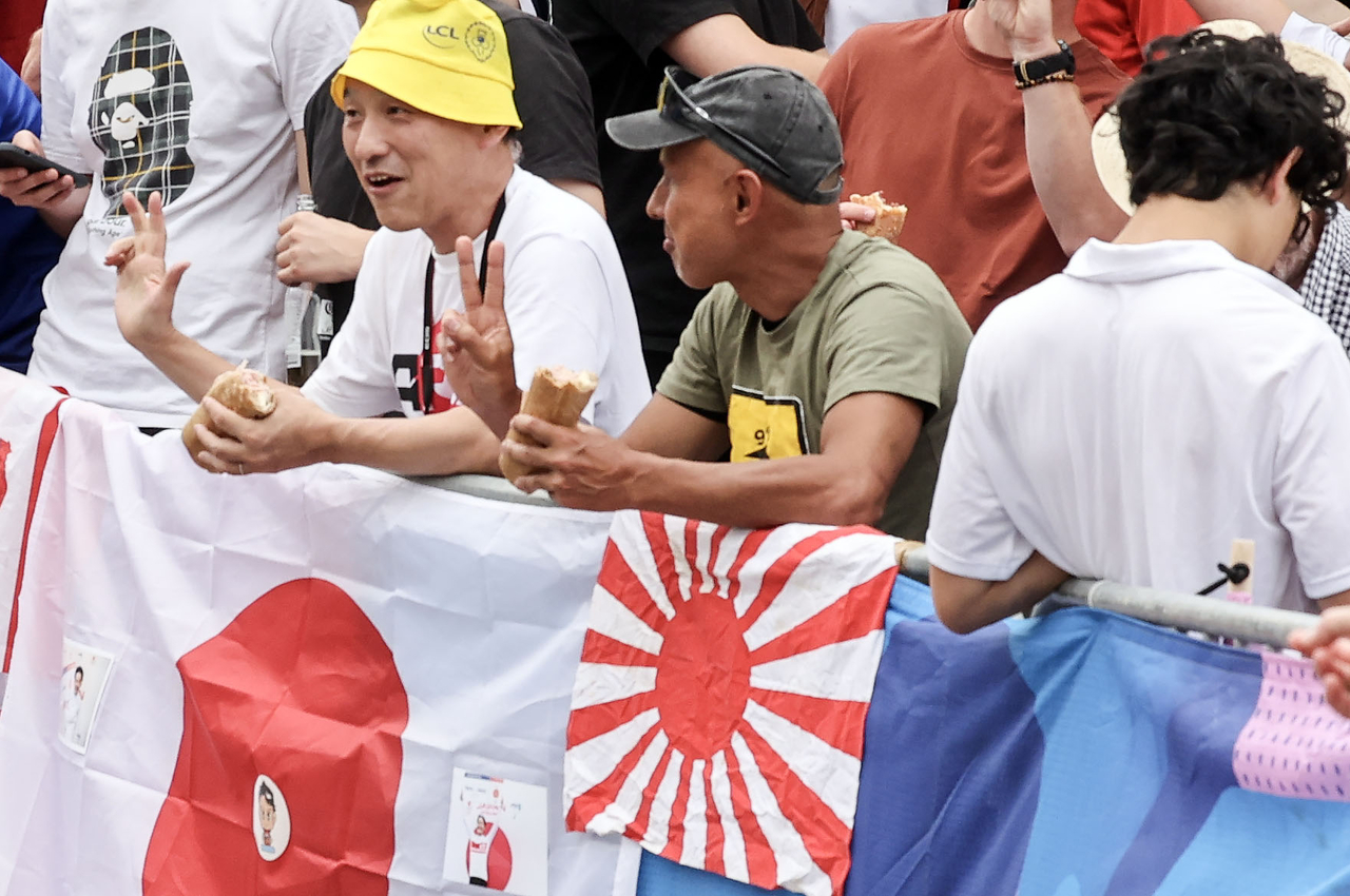 去る 2024年パリ夏季オリンピックサイクル男道路競技途中モングマルト丘にある日本人が日の丸と並んで日本帝国主義を象徴する旭日昇天期をかけておいて応援をする姿. [オリンピック写真共同取材団]