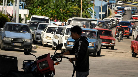 Un conductor carga combustible en su motocicleta, en La Habana. 