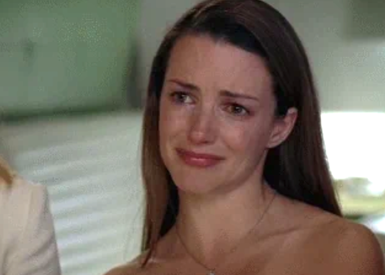 Person appearing emotional with teary eyes and a slight smile, conveying mixed feelings in a close-up setting