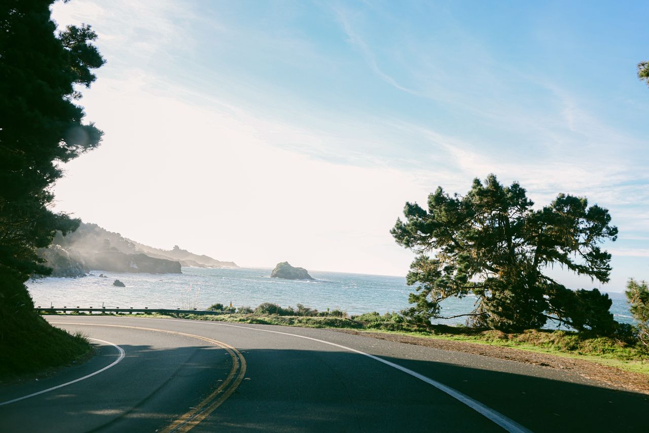 A road curving around the coast along the Pacific Coast Highway