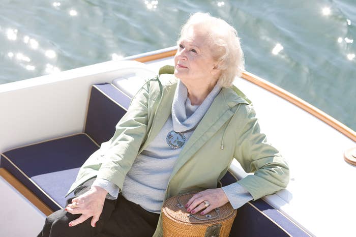 A person relaxing on a boat, wearing a light jacket