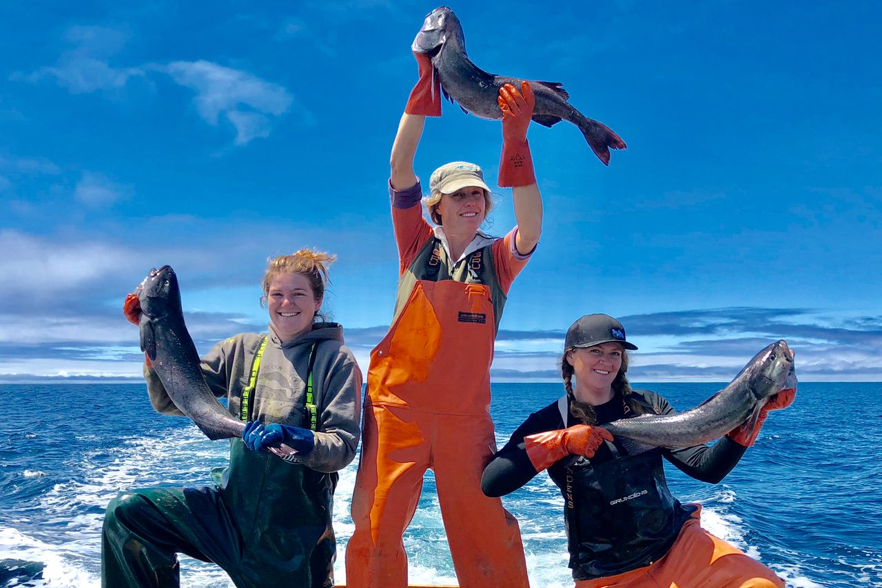 Three women hold up large fish from their seafood catch experience at Princess Seafood
