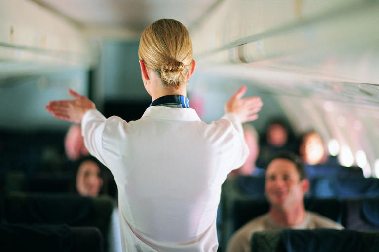 A flight attendant doing a safety demonstration on a plane. James Lauritz/Getty Images