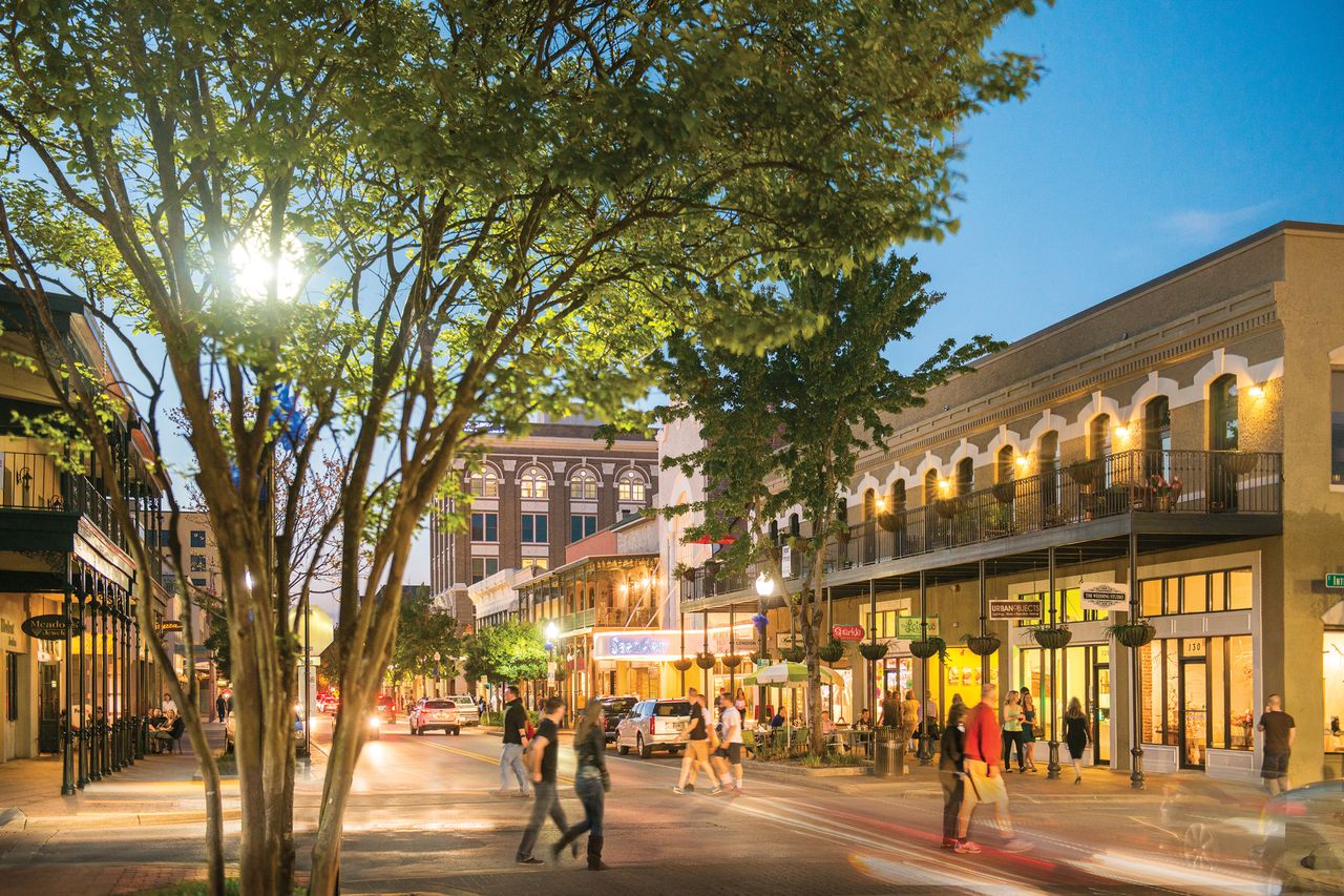 People walking in downtown Pensacola at dusk
