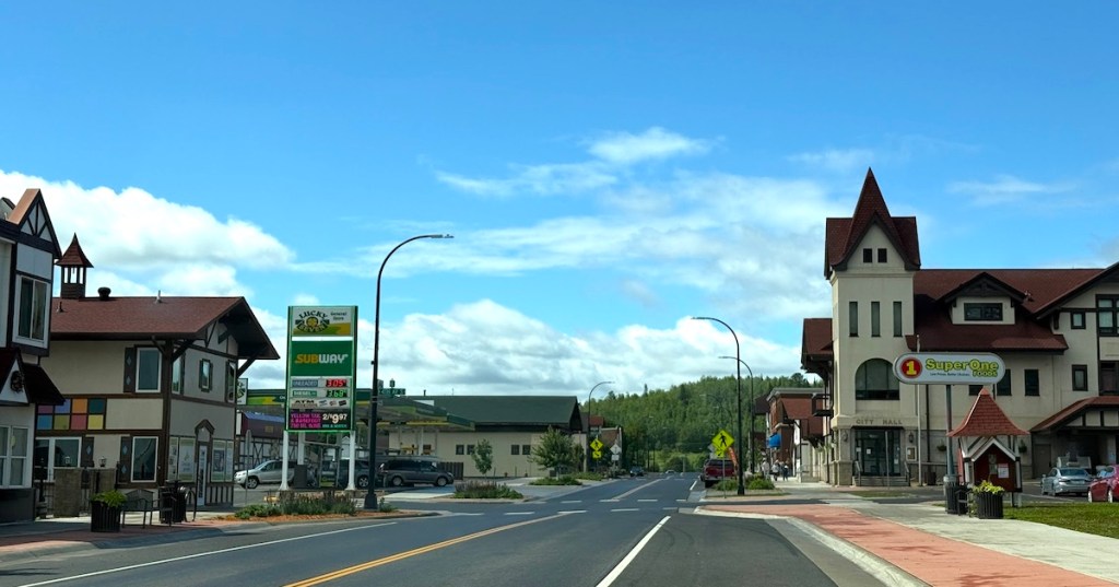 The Bavarian-themed architecture of downtown Biwabik, Minnesota, features the City Hall tower and local businesses along the main street.