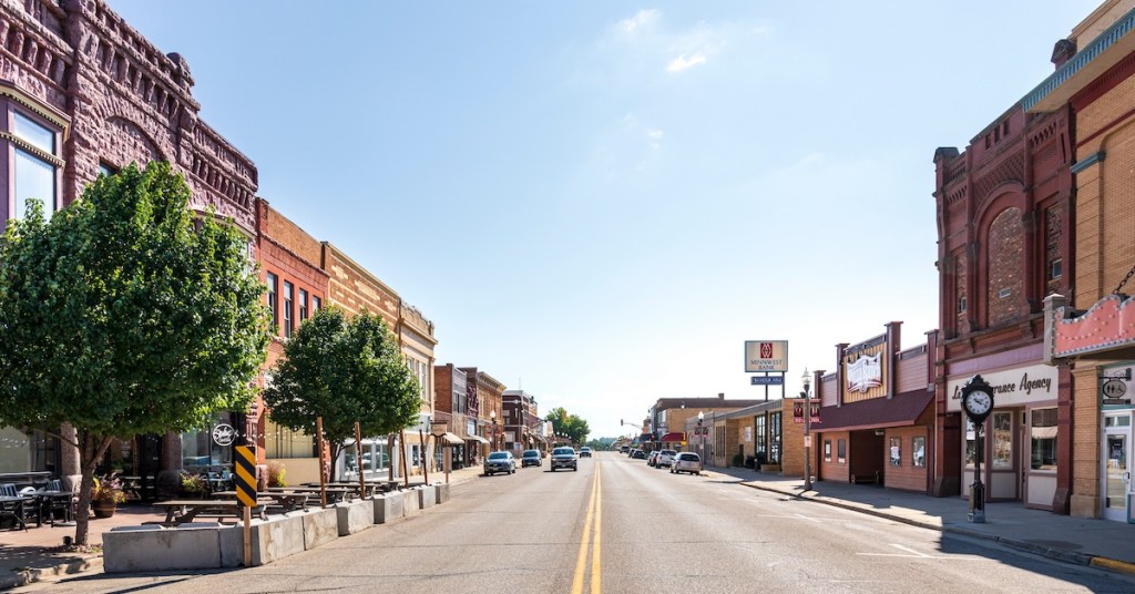 Historic buildings made of local pink quartzite line the sunny main street of downtown Luverne, Minnesota.