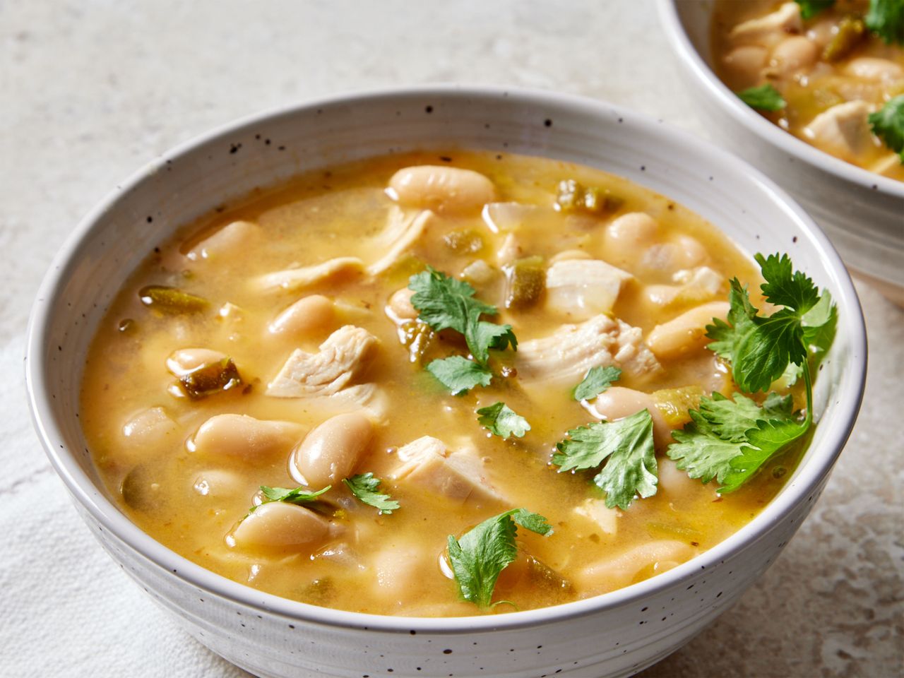 A bowl of white chicken chili garnished with cilantro