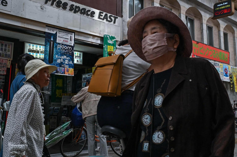 Elderly shoppers walk through an old covered shopping street in the Nishinari ward of Osaka on October 1, 2025. Photo: AFP