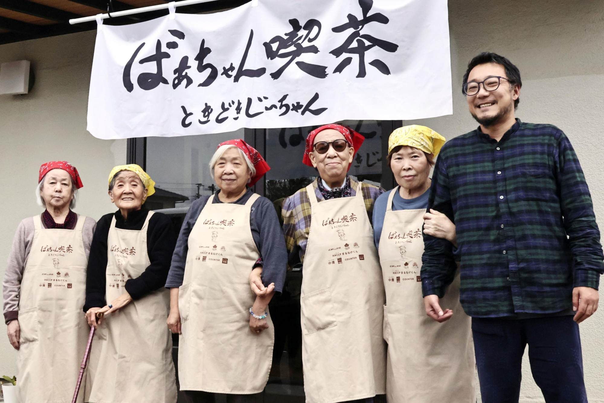 Mitsuru Okuma (right) poses for a photo with Ukiha no Takara employees outside Grandma's Tearoom. Photo: Kyodo