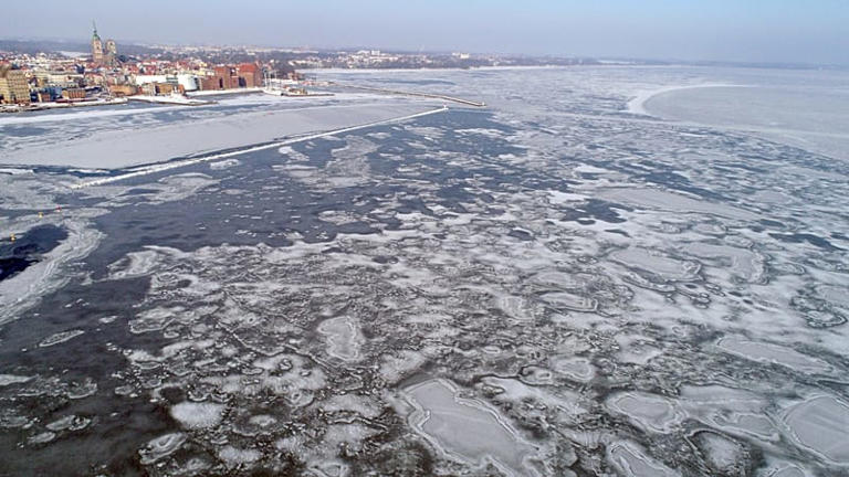 Poles flock to frozen Baltic Sea beach as temperatures plunge