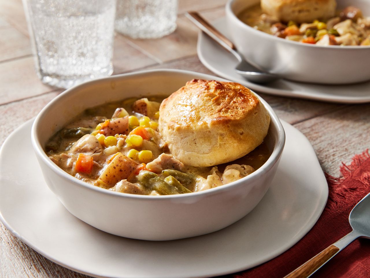 Slow Cooker Chicken Pot Pie With Biscuits in a bowl with another bowl in the background