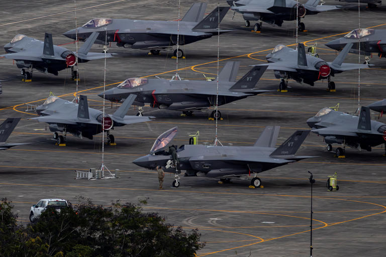 Personnel work on a U.S. Air Force F-35 Lightning II jet fighter on the tarmac in Puerto Rico.