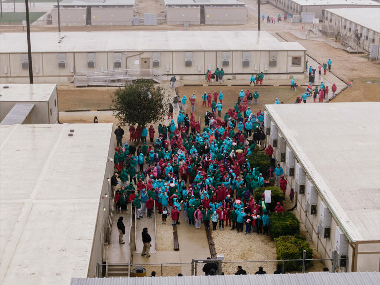 Detainees at the Dilley Immigration Processing Center wave signs during a demonstration in January. (Brenda Bazán / AP)