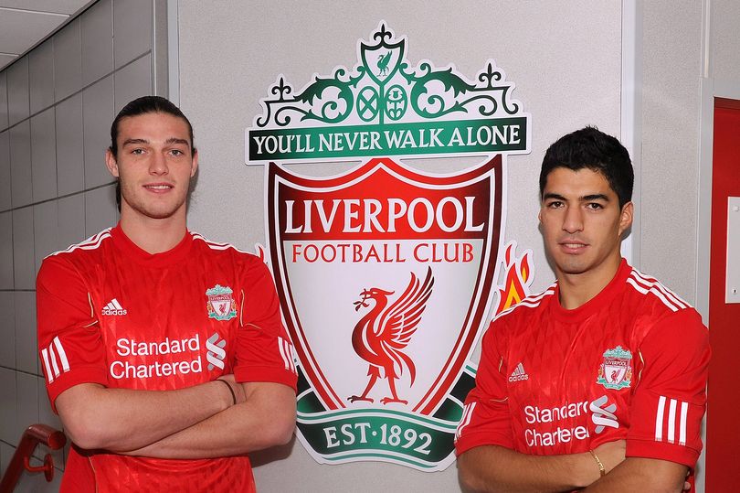 Andy Carroll and Luis Suarez pose in front of Liverpool badge