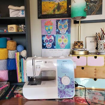 Sewing machine on a craft desk with yarn, books, and colorful art supplies, creating a vibrant and creative workspace