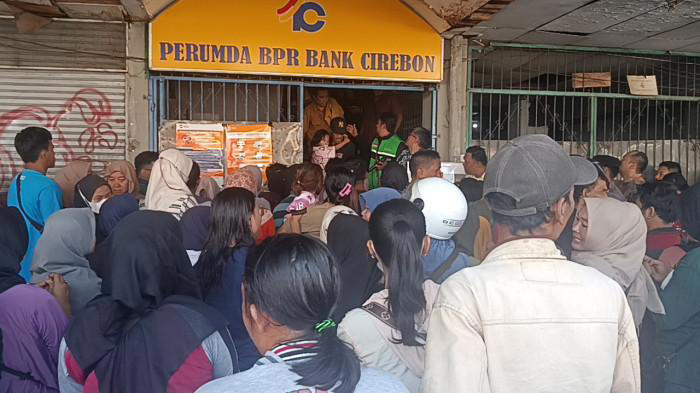 RAMAI-RAMAI KE BANK - Ratusan warga tampak memadati halaman Kantor Perumda BPR Bank Cirebon, Jalan Talang, Kecamatan Lemahwungkuk, Kota Cirebon, Selasa (10/2/2026). Mereka datang silih berganti sejak pagi, menyusul kabar pencabutan izin usaha bank milik daerah tersebut oleh Otoritas Jasa Keuangan (OJK) (Tribun Cirebon/Ahmad Imam Baehaqi)