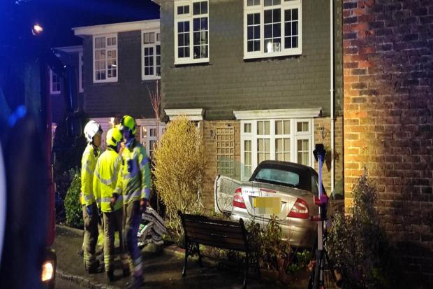 Man detained after car crashes into house
