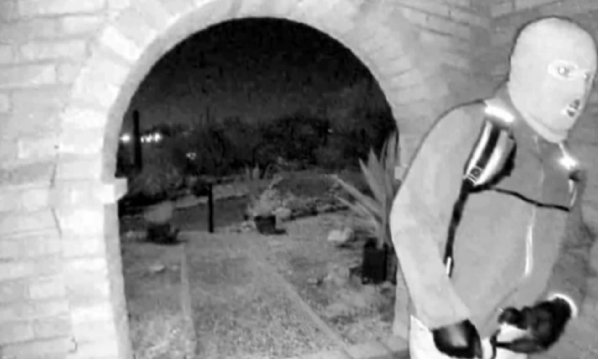 Terrifying masked figure in latex gloves with backpack and gun seen on ...