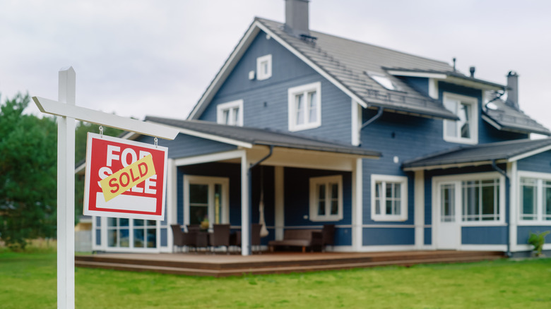 large house with sold sign out front