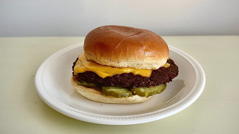 Bob Evan's cheeseburger on a small white plate in front of a neutral background