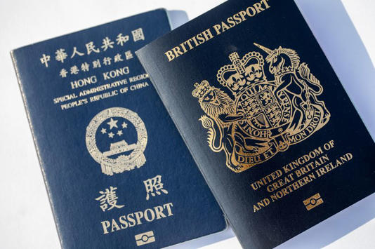 A copy of the British National (Overseas) passport, right, with Hong Kong Special Administrative Region (HKSAR) passport arranged in Hong Kong, China, on Saturday, Jan. 30, 2021. Prime Minister Boris Johnson estimates about 300,000 Hong Kong citizens will take advantage of a new visa route to leave the former British colony and settle in the U.K., despite nearly three million people being eligible. Photographer: Paul Yeung/Bloomberg via Getty Images