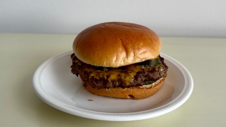 Applebee's cheeseburger on a small white plate in front of a neutral background