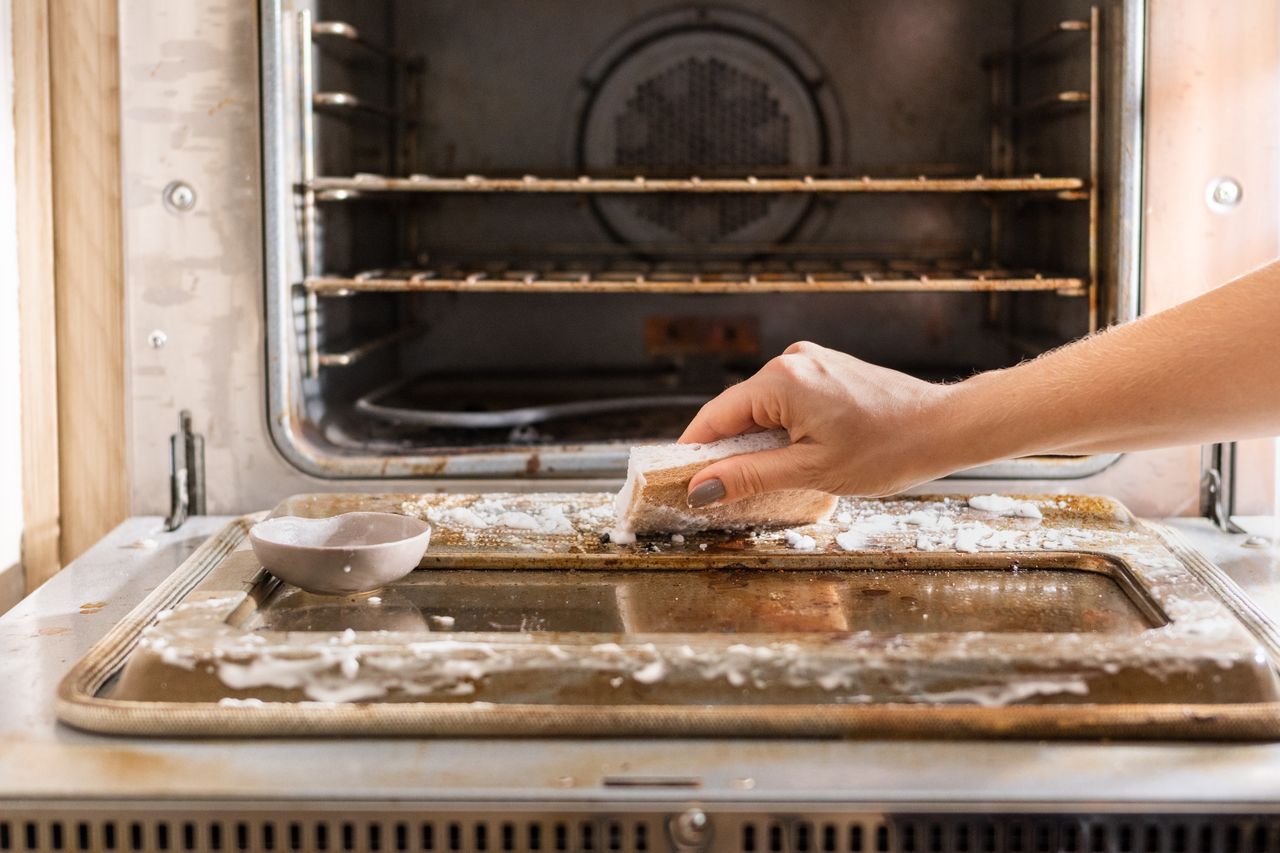 Baking soda sprinkled onto a soiled oven door