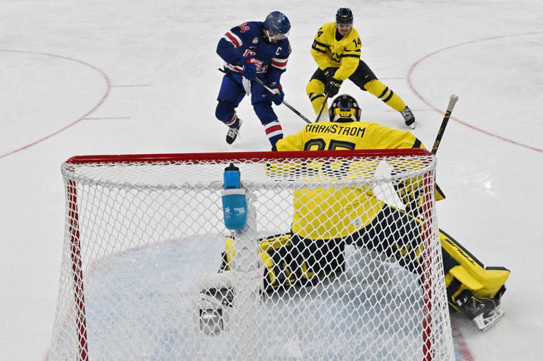 Team USA's Auston Matthews fights for the puck in front of Sweden's net