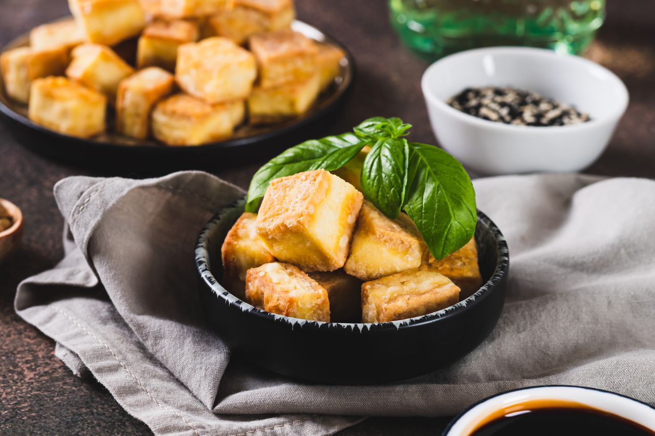 Pan fried tofu cubes in a small dish on a table