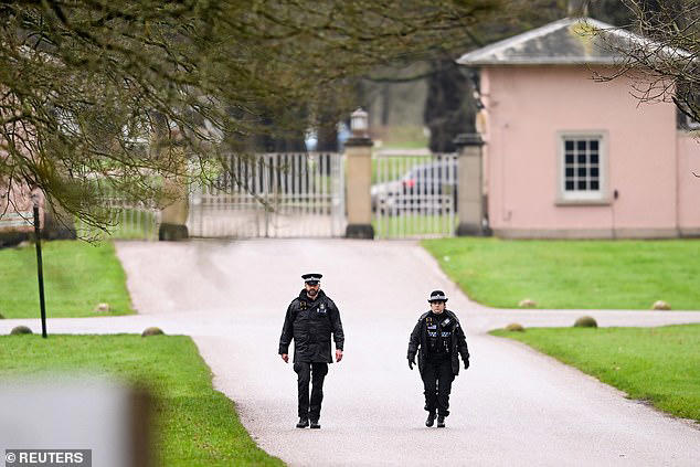 Police officers walk near the entrance to Royal Lodge on Thursday 