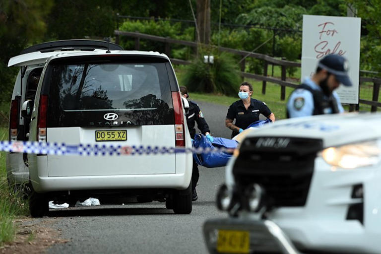 NSW Police forensic officers remove a large evidence bag from the Dural property.