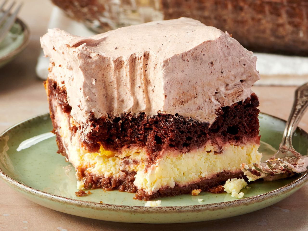 A slice of layered Italian love cake with whipped topping on a plate