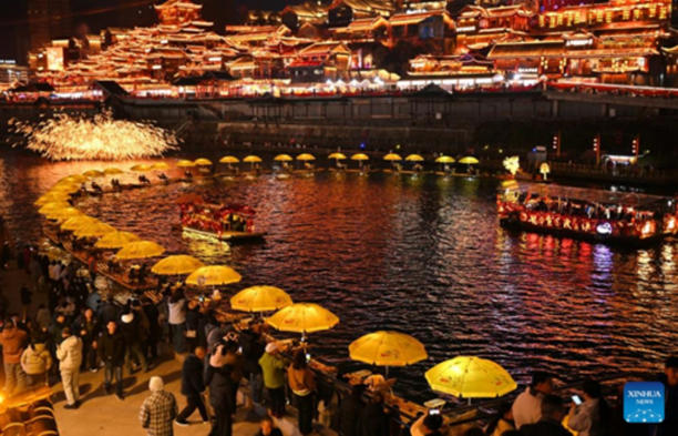 Du khách trải nghiệm đi bè tre tại huyện Tuyên Ân, tỉnh Hồ Bắc (Trung Quốc), trong không khí lễ hội Tết rộn ràng. (Nguồn: Tân Hoa xã)