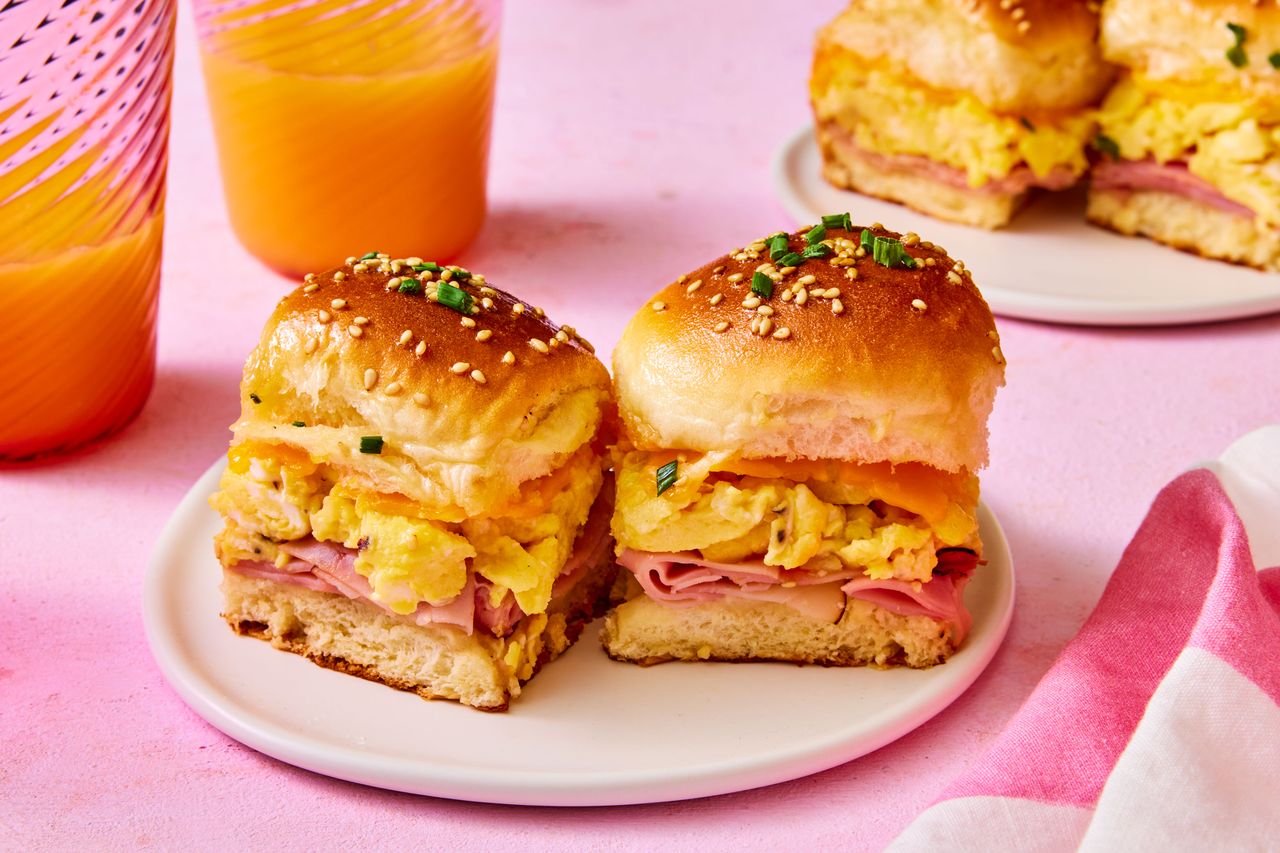 Southern Living Hawaiian Rolls Breakfast Sandwiches on a plate to serve with glasses of orange juice