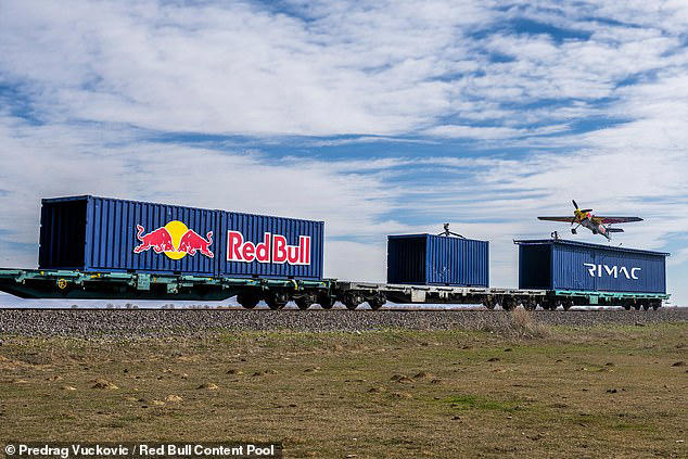 Watch the moment a pilot lands a plane on a train travelling at 75mph ...