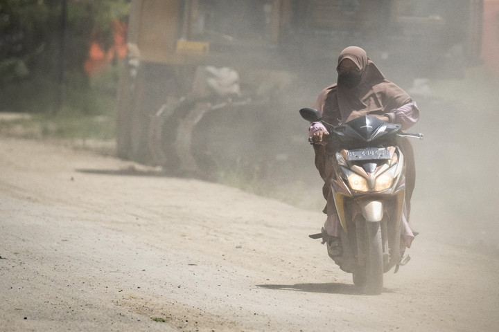 Warga Aceh Tamiang menutup hidung saat beraktivitas di luar ruangan.