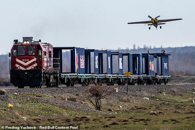 Watch the moment a pilot lands a plane on a train travelling at 75mph ...