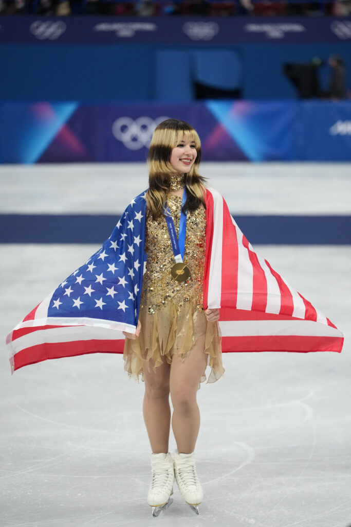 Feb 19, 2026; Milan, Italy; Alysa Liu of the United States celebrates with the gold medal and the flag after the medal ceremony for the women’s free skate during the Milano Cortina 2026 Olympic Winter Games at Milano Ice Skating Arena. Mandatory Credit: James Lang-Imagn Images