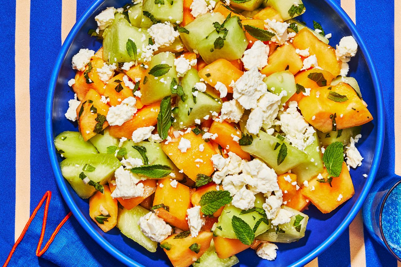 Melon Salad in a blue bowl on a blue striped surface