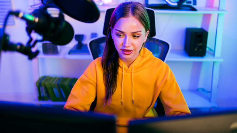 A video game streamer glances over to one of her computer screens.