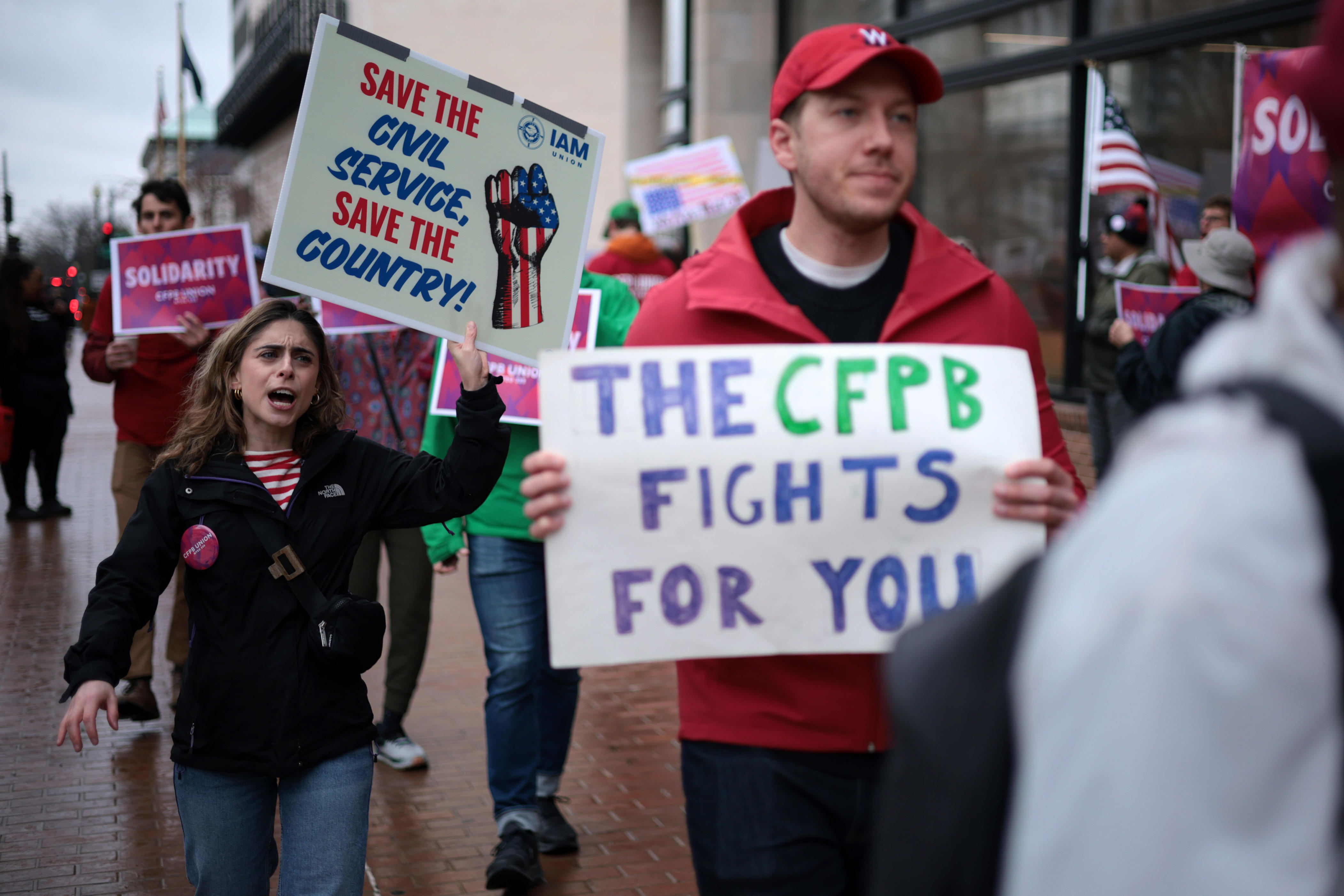 WASHINGTON, DC - MARCH 24: Activists participate in a rally outside the Consumer Financial Protection Bureau (CFPB) on March 24, 2025 in Washington, DC. Activists held a rally to support federal workers affected by DOGE cuts. (Photo by Alex Wong/Getty Images)