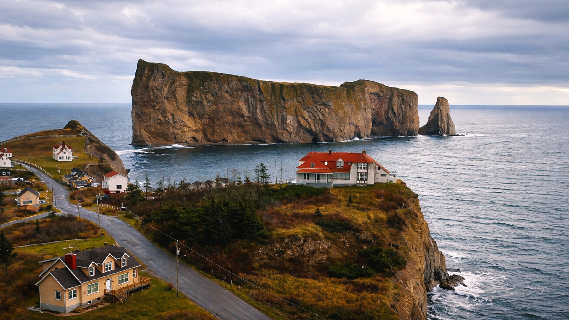 A coastal town facing a giant rock wall