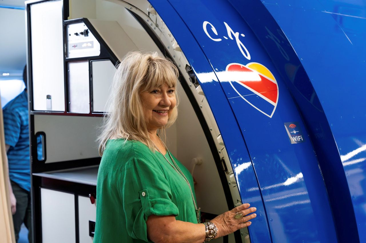 A person standing near an airplanes boarding area with a heart logo visible on the planes exterior