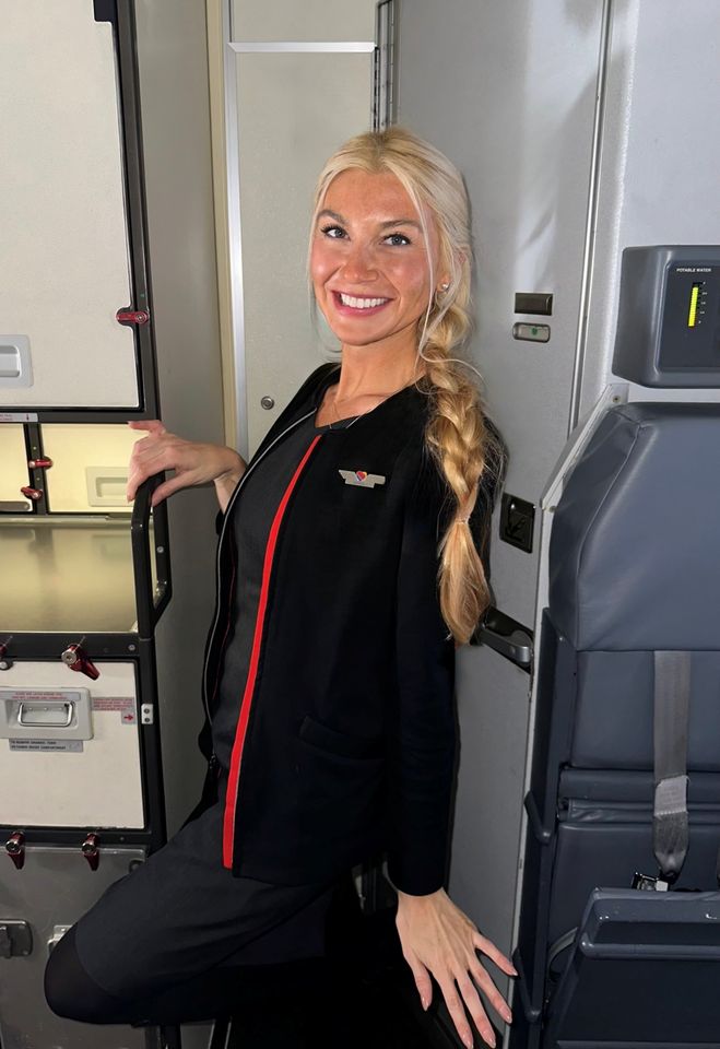 Flight attendant standing near an aircraft cabin galley
