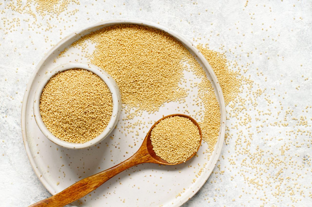 rave amaranth grain on white plate with wood spoon