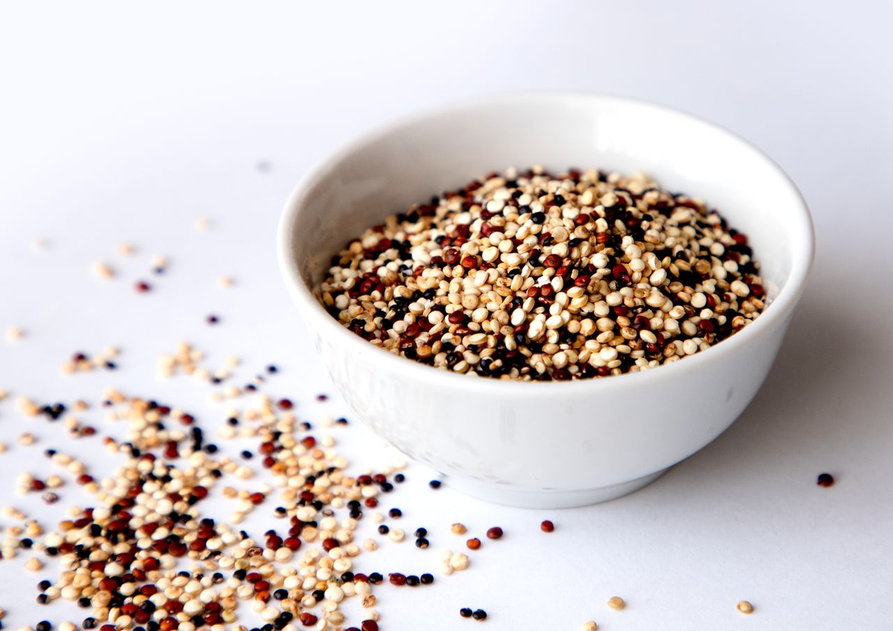 uncooked tricolor quinoa in a white bowl