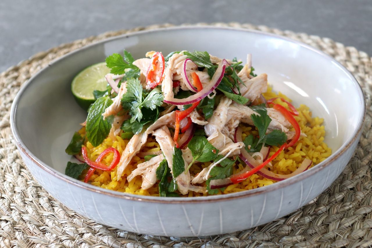 Asian rice bowl with chicken, red onions, and herbs