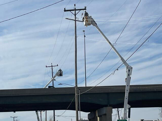 Power line work across Kansas Avenue bridge in Topeka