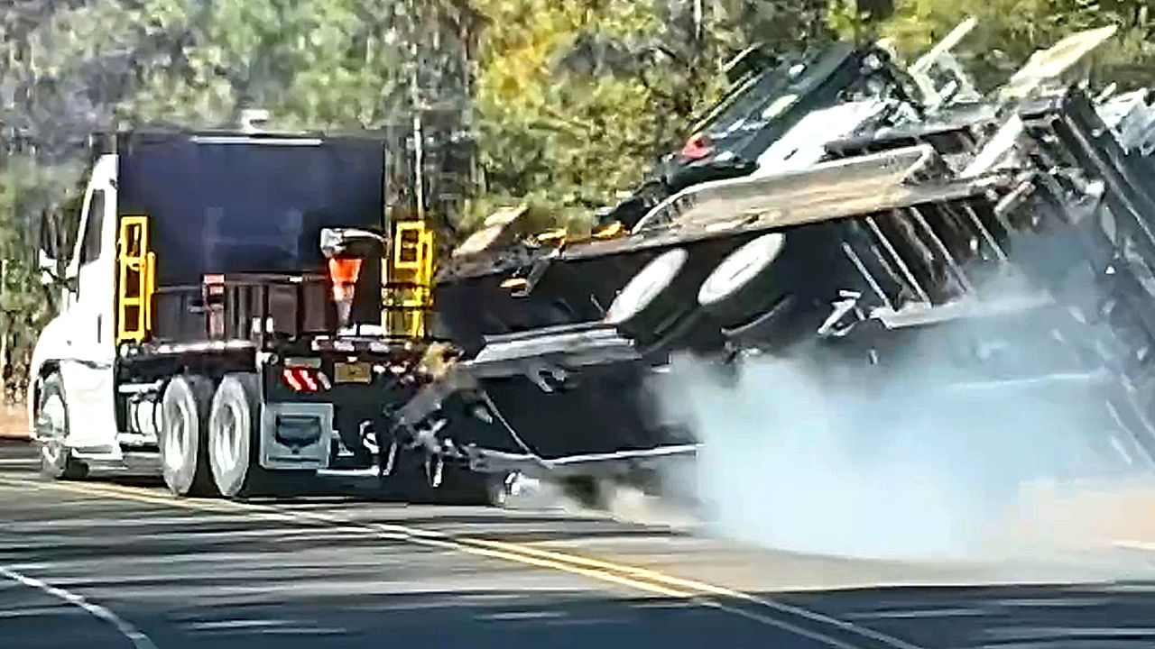 Poorly-loaded trailer tips over on bend
